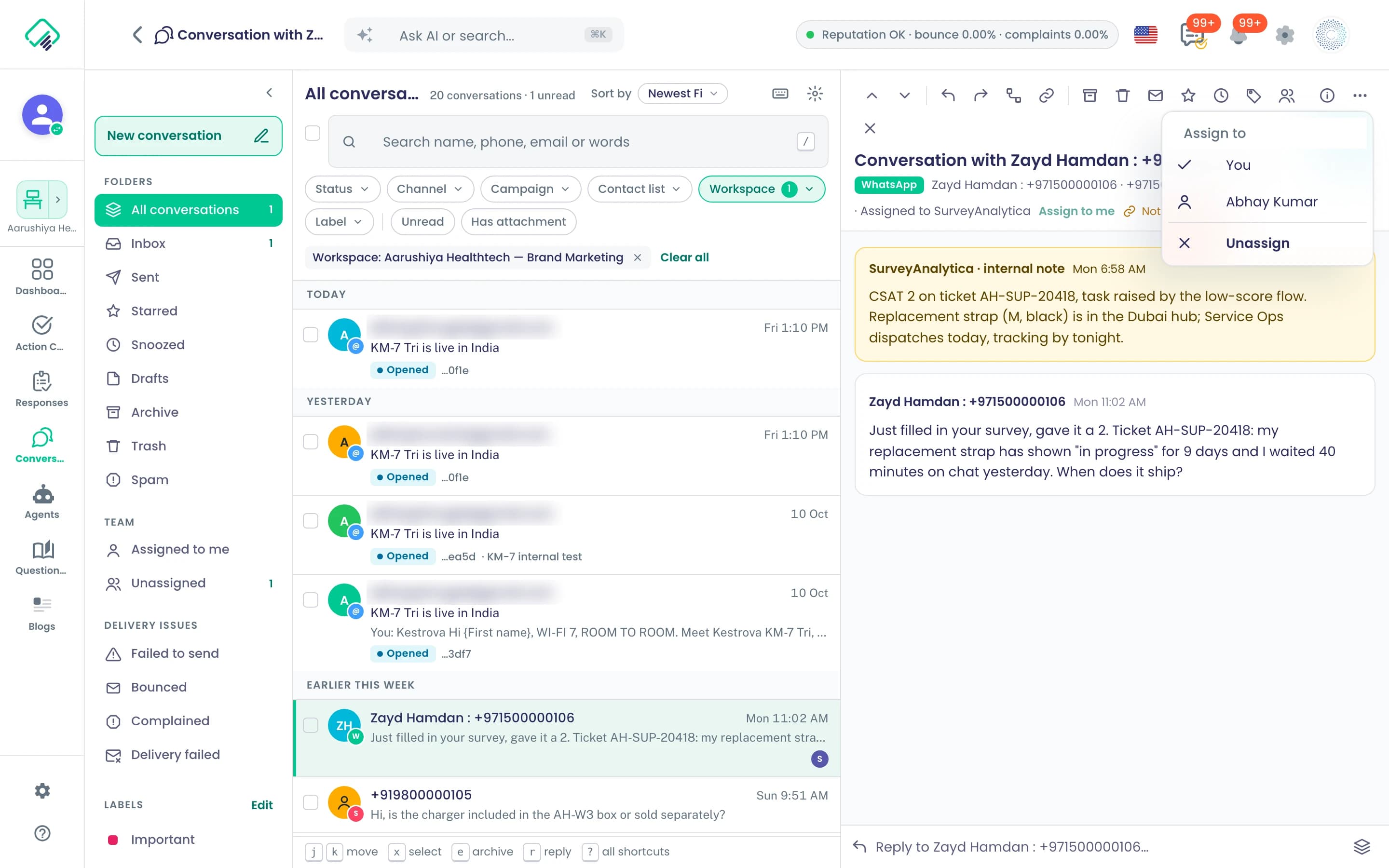 Das Menü „Assign“ in einer WhatsApp-Unterhaltung listet die Mitglieder des Workspace auf, „You“ und Abhay Kumar, dazu „Unassign“; die Kopfzeile lautet „Assigned to SurveyAnalytica“; persönliche E-Mail-Adressen in der Liste unkenntlich gemacht